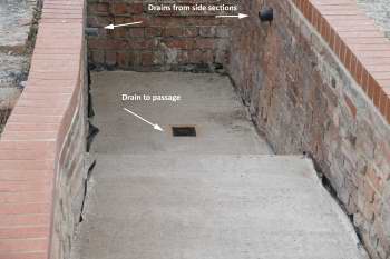 The positions of the drains have been marked in a photo of a concrete lined brick channel